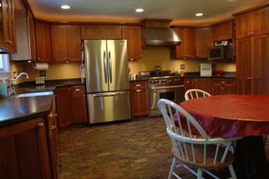 Mid-sized elegant u-shaped eat-in kitchen photo in Indianapolis with a single-bowl sink, recessed-panel cabinets, dark wood cabinets, stainless steel appliances and no island