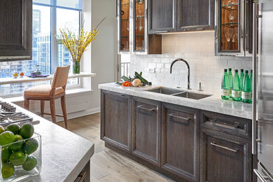 Example of a mid-sized trendy u-shaped light wood floor and beige floor enclosed kitchen design in San Diego with recessed-panel cabinets, dark wood cabinets, marble countertops, white backsplash, subway tile backsplash, stainless steel appliances and an island