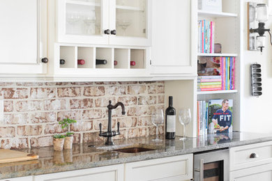Kitchen - country dark wood floor and brown floor kitchen idea in Charleston with a farmhouse sink, shaker cabinets, white cabinets, granite countertops, brick backsplash, stainless steel appliances, an island and beige countertops