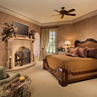 Réalisation d'une grande chambre méditerranéenne avec un mur beige, une cheminée standard et un manteau de cheminée en plâtre.