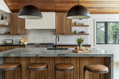 Example of a large transitional l-shaped light wood floor, brown floor and wood ceiling eat-in kitchen design in Sacramento with a single-bowl sink, shaker cabinets, medium tone wood cabinets, quartzite countertops, white backsplash, subway tile backsplash, paneled appliances, an island and blue countertops