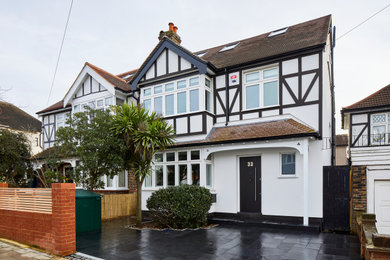 Photo of a large and white traditional render semi-detached house in London with three floors, a pitched roof, a tiled roof and a red roof.