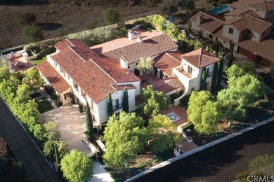 Example of a large tuscan beige two-story stucco house exterior design in Orange County with a tile roof