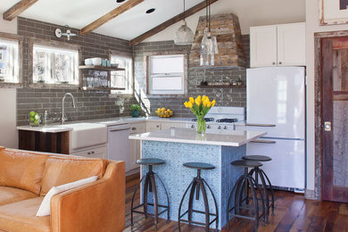 Inspiration for a mid-sized eclectic l-shaped open plan kitchen in Other with a farmhouse sink, recessed-panel cabinets, white cabinets, white appliances, medium hardwood floors, with island and brown floor.