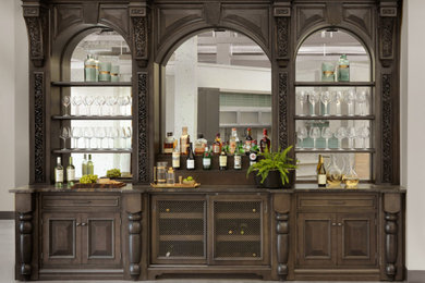 Traditional home bar in St Louis with brown cabinets, quartzite benchtops, mirror splashback and brown benchtop.