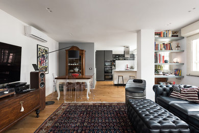 Modelo de salón tipo loft urbano pequeño con paredes blancas, suelo de madera clara, televisor colgado en la pared y bandeja