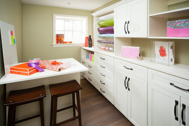 Inspiration for a mid-sized timeless built-in desk dark wood floor craft room remodel in Other with beige walls