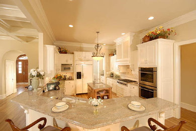 Elegant medium tone wood floor kitchen photo in Dallas with a double-bowl sink, raised-panel cabinets, white cabinets, granite countertops, white backsplash, stone tile backsplash and stainless steel appliances