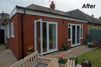 Photo of a small traditional bungalow brick and rear house exterior in Buckinghamshire with a flat roof.