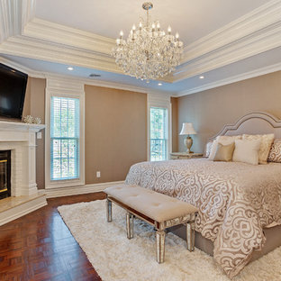 Inspiration for a mid-sized traditional master bedroom in New York with beige walls, dark hardwood floors, a corner fireplace and a brick fireplace surround.