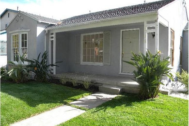 Mid-sized traditional gray one-story stucco house exterior idea in Los Angeles with a hip roof and a shingle roof