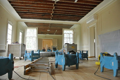 Example of a mid-sized classic formal and enclosed medium tone wood floor living room design in Newark with beige walls, no fireplace, a brick fireplace and no tv
