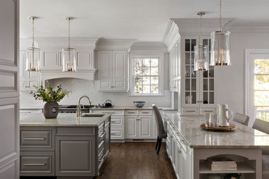 Example of a large classic dark wood floor and brown floor kitchen design in New York with a single-bowl sink, raised-panel cabinets, white cabinets, quartzite countertops, white backsplash, porcelain backsplash, paneled appliances, an island and gray countertops