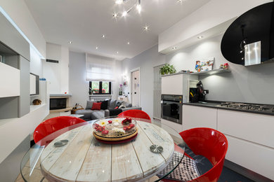 Ispirazione per una piccola sala da pranzo aperta verso il soggiorno minimal con pareti grigie, pavimento con piastrelle in ceramica e camino ad angolo