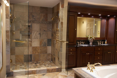 Inspiration for a large timeless master beige tile and porcelain tile porcelain tile and beige floor bathroom remodel in Other with raised-panel cabinets, dark wood cabinets, beige walls, an undermount sink, granite countertops and a hinged shower door