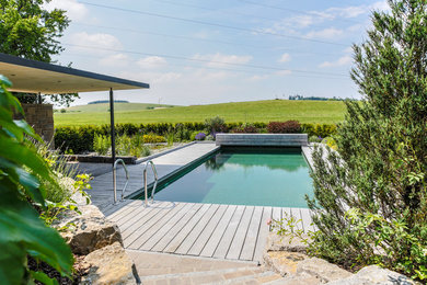 This is an example of a mid-sized country backyard rectangular lap pool in Stuttgart with decking.
