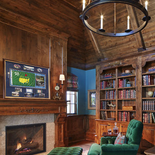 Inspiration for a large traditional home office in Minneapolis with a library, brown walls, dark hardwood floors, a standard fireplace, a wood fireplace surround and brown floor.