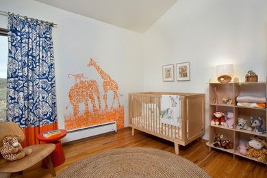 Imagen de habitación de bebé neutra abovedada tradicional renovada de tamaño medio con paredes blancas, suelo de madera en tonos medios, suelo marrón y papel pintado