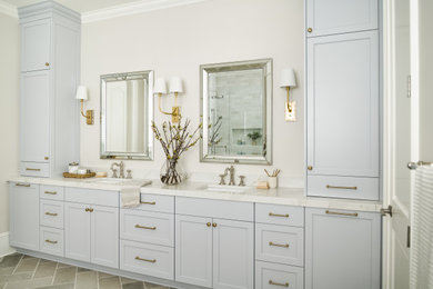 Example of a large transitional master double-sink, coffered ceiling, ceramic tile and gray floor bathroom design in Charlotte with blue cabinets, beige walls, a hinged shower door, a built-in vanity, shaker cabinets, an undermount tub, an undermount sink, quartz countertops and white countertops