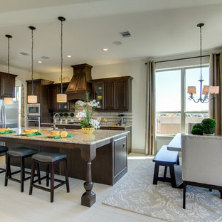 Large eat-in kitchen ideas - Eat-in kitchen - large l-shaped porcelain tile eat-in kitchen idea in Dallas with an undermount sink, raised-panel cabinets, dark wood cabinets, granite countertops, beige backsplash, glass tile backsplash, stainless steel appliances and an island