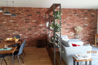 This is an example of a rustic living room in London with red walls and brick walls.