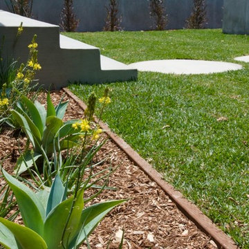 Formed round concrete entry pavers soften linear focus.