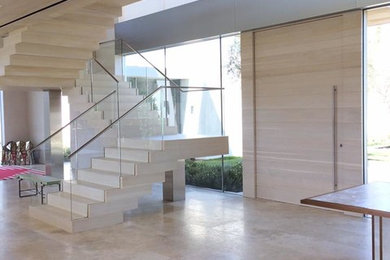 Inspiration for a large contemporary porcelain tile entryway remodel in Los Angeles with white walls and a light wood front door