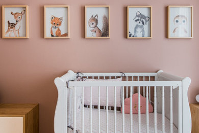 Design ideas for a medium sized scandinavian nursery for girls in Paris with pink walls, light hardwood flooring and all types of wall treatment.