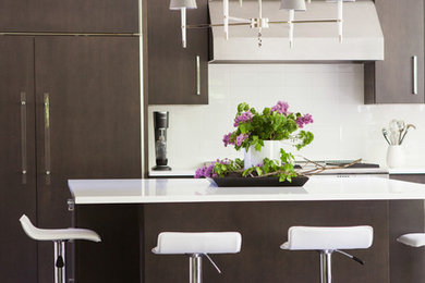 Example of a mid-sized trendy l-shaped slate floor eat-in kitchen design in New York with flat-panel cabinets, dark wood cabinets, white backsplash, paneled appliances, a single-bowl sink, quartz countertops, subway tile backsplash and an island