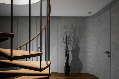 Ejemplo de escalera de caracol actual grande con escalones de madera, contrahuellas de metal y barandilla de metal