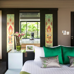 Esempio di una camera matrimoniale etnica di medie dimensioni con pareti marroni, pavimento in marmo e pavimento nero