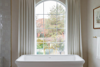Inspiration for a mid-sized modern master beige tile and mosaic tile limestone floor, beige floor, double-sink and exposed beam bathroom remodel in Los Angeles with flat-panel cabinets, medium tone wood cabinets, a bidet, beige walls, an undermount sink, marble countertops, a hinged shower door and a built-in vanity