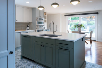 Mid-sized transitional u-shaped porcelain tile and multicolored floor kitchen photo in Seattle with shaker cabinets, stainless steel appliances, an island, white countertops, an undermount sink, quartz countertops, gray backsplash and subway tile backsplash