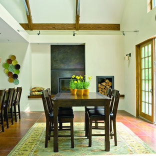 This is an example of a mid-sized traditional kitchen/dining combo in Seattle with concrete floors, white walls, a standard fireplace, a concrete fireplace surround and brown floor.