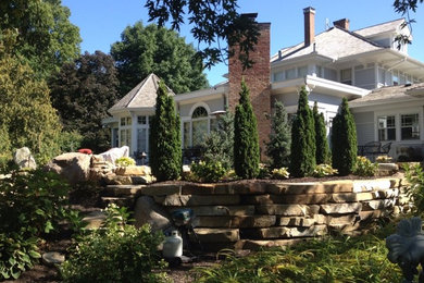 This is an example of a large traditional full sun backyard mulch landscaping in Omaha for spring.