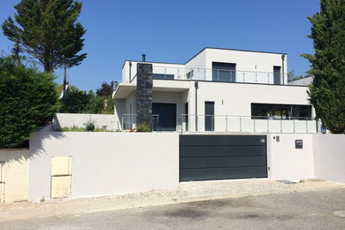 Large contemporary two-storey white house exterior in Lyon with a flat roof.
