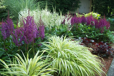 Photo of a mid-sized traditional partial sun backyard mulch formal garden in Boston for summer.