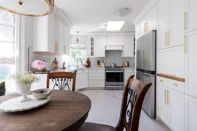 Mid-sized transitional l-shaped ceramic tile and beige floor eat-in kitchen photo in Calgary with an undermount sink, shaker cabinets, white cabinets, quartz countertops, white backsplash, ceramic backsplash, stainless steel appliances, no island and white countertops