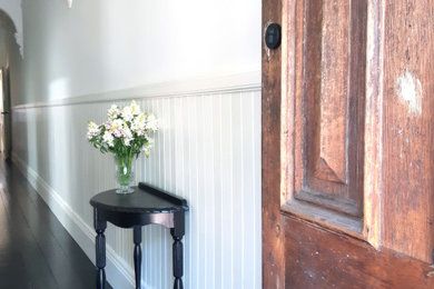 Inspiration for a traditional entryway in Geelong with white walls, dark hardwood floors, black floor and decorative wall panelling.