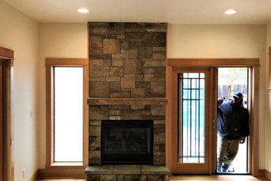 Example of a mid-sized farmhouse open concept medium tone wood floor family room design in Other with beige walls, a two-sided fireplace and a stacked stone fireplace