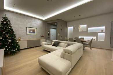 Immagine di un soggiorno moderno di medie dimensioni e aperto con pareti bianche e parquet chiaro