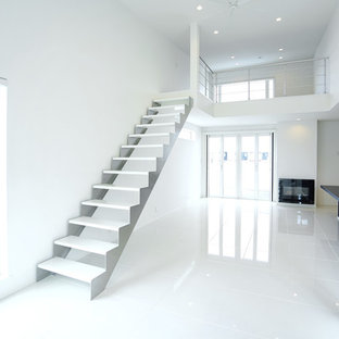 Foto di un ampio soggiorno minimalista aperto con sala formale, pareti bianche, pavimento in marmo, camino classico, cornice del camino in intonaco e pavimento bianco