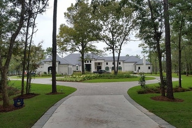 Photo of a large traditional front yard brick driveway in Miami.