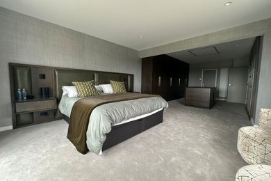 Large master bedroom in West Midlands with carpet.