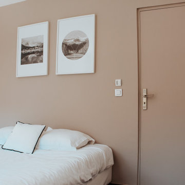 Petite chambre mur beige duo de cadres dessus lit