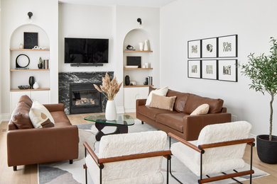 Design ideas for a mid-sized midcentury open concept living room in Toronto with light hardwood floors, a standard fireplace, a stone fireplace surround and a wall-mounted tv.