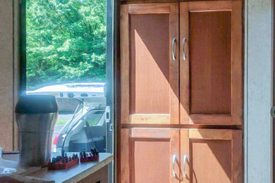 シャーロットにある中くらいなトランジショナルスタイルのおしゃれなキッチン (シェーカースタイル扉のキャビネット、中間色木目調キャビネット、珪岩カウンター、アイランドなし、マルチカラーのキッチンカウンター) の写真