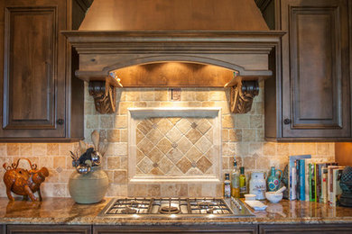 Example of a mid-sized classic l-shaped dark wood floor and brown floor eat-in kitchen design in Other with an undermount sink, raised-panel cabinets, medium tone wood cabinets, granite countertops, beige backsplash, ceramic backsplash, stainless steel appliances and an island