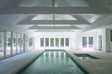 Design ideas for a large modern indoor rectangular lap pool in New York with a hot tub and stamped concrete.