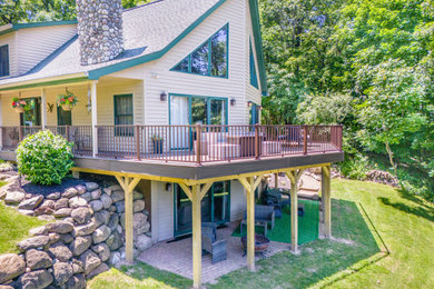 Example of a huge trendy backyard ground level metal railing deck design in Detroit
